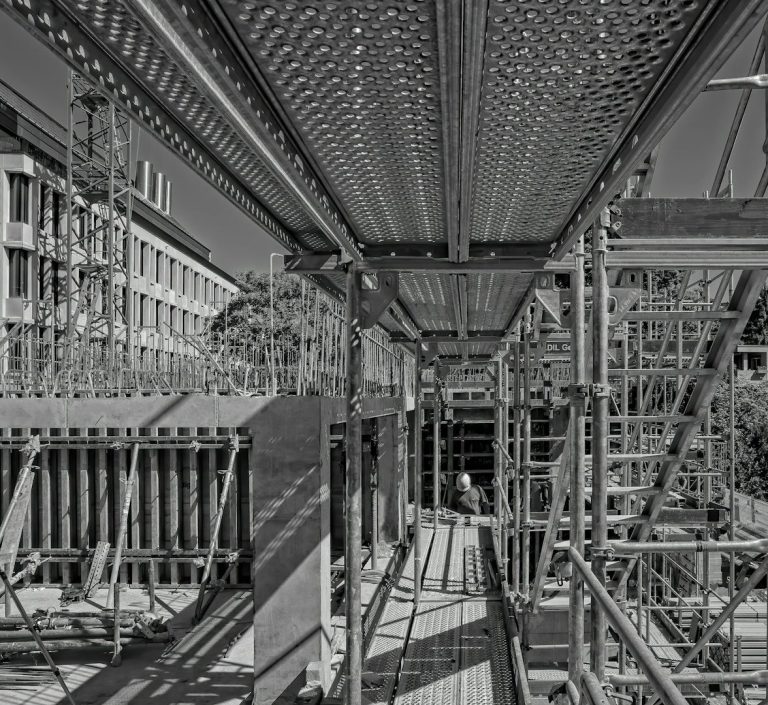 Blick auf ein Gerüst mit robusten Metallstreben und Schattenwurf.